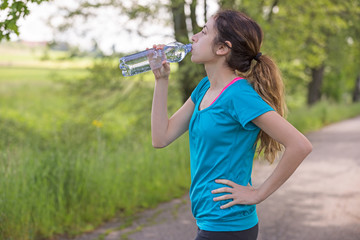 Runner woman drinking water