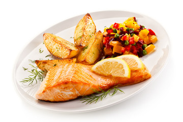 Fried salmon and vegetables on white background 