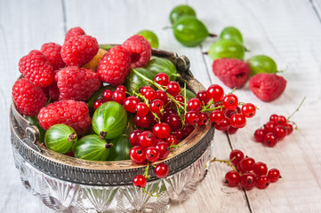 Mix of fresh organic berries isolated on vintage wooden table background