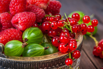 Mix of fresh organic berries isolated on vintage wooden table background