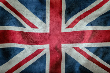 Fototapeta premium Closeup of Union Jack flag. UK Flag. British Union Jack flag blowing in the wind. Concrete background.