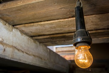 Old dusty round glowing tungsten lamp in the basement