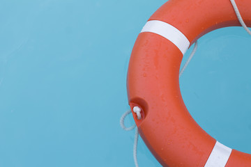 Orange lifebuoy in the swimming pool with turquoise water