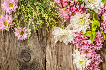Different flowers on the wooden background top view
