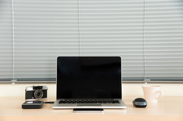 Open laptop with external harddrive,  mouse, camera, smart phone