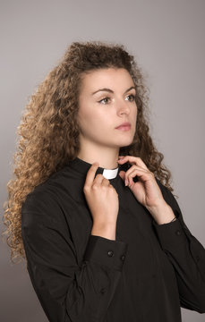 Young Woman Priest Adjusting Her Clerical Collar