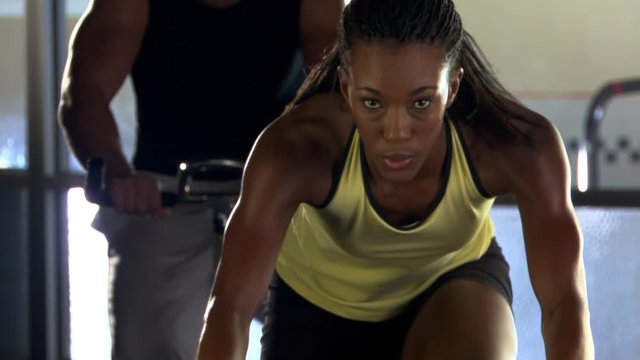 Young woman riding stationary bike in spinning clas