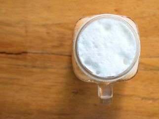 Milk tea with ice in Glass handle on wooden table.