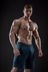 Obraz na płótnie Canvas Muscular bodybuilder guy doing posing over black background