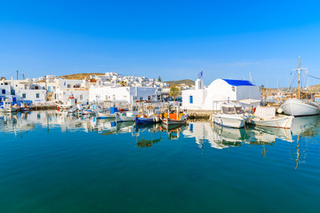 Fototapeta na wymiar A view of Naoussa port with Greek style church and traditional fishing boats, Paros island, Cyclades, Greece