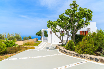 A typical white house in green rural landscape of Imerovigli village on Santorini island, Greece