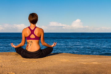 Fototapeta na wymiar Young woman makes Yoga on a Beach