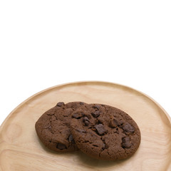 Chocolate cookies with chocolate chip on round wooden plate isolated on white background with copy space