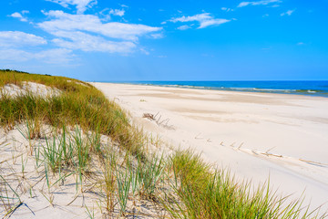 Fototapeta na wymiar A view of white sand beach and dune with grass at Baltic Sea, Bialogora coastal village, Poland
