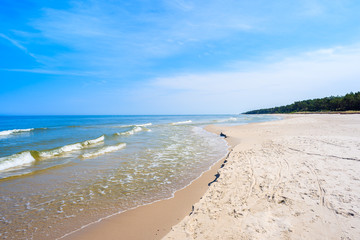 A view of white sand beach and waves of blue Baltic Sea, Bialogora coastal village, Poland