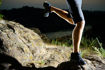 Close-up of Sportsman's Legs Running on the Rocky Mountain Trail at Night. Active Lifestyle