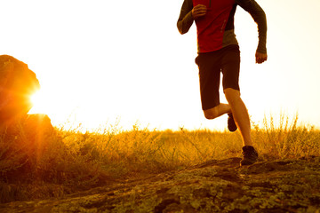 Close-up of Sportsman's Legs Running on the Rocky Mountain Trail at Sunset. Active Lifestyle