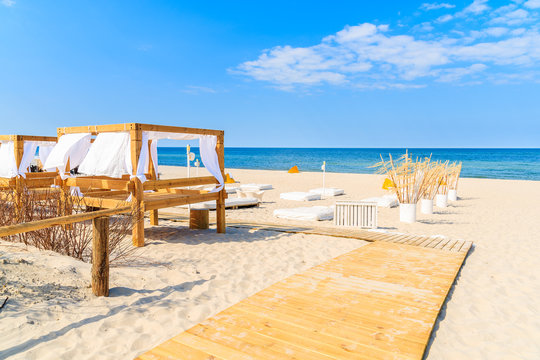 Fototapeta Pathway to sandy beach with sun beds in Jurata village on Hel peninsula, Baltic Sea, Poland