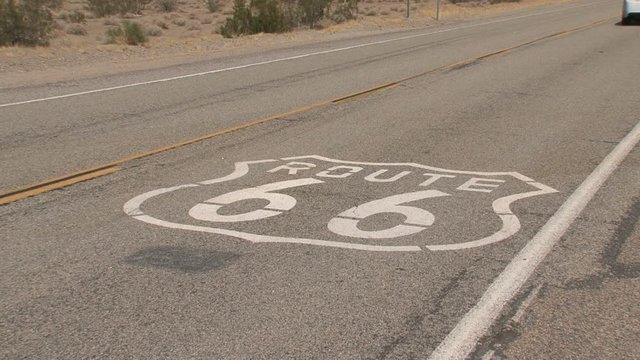 Car driving over the Route 66 sign at the road