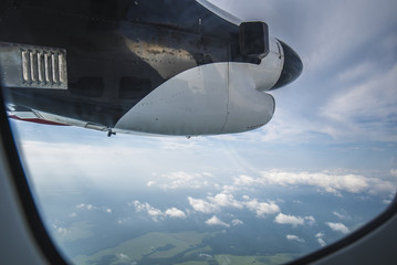 Fototapeta na wymiar Clouds, screw, sky as seen in window of an aircraft
