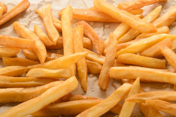fresh fried golden brown french fries in brown paper kitchen