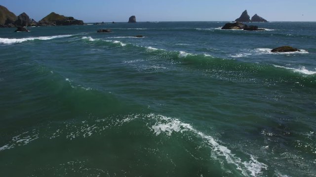 Jagged sea stacks jutting out of green water on the Oregon coast