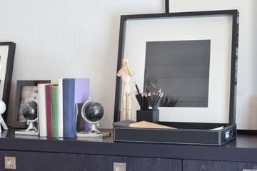 decorative tray with book and pencils on wooden table at home