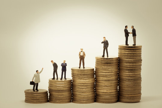 Various people standing on stacks of coins