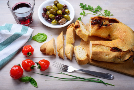 Sun-dried tomato bread with olives, cherry tomatoes and red wine