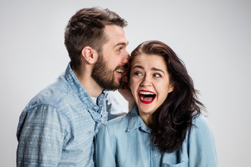 Young man whispering to woman a secret