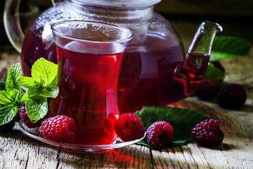 Useful raspberry tea with mint, vintage wood background, selecti