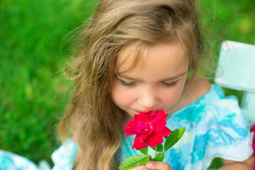 Fototapeta premium smiling girl with the bouquet of roses sits on a bench