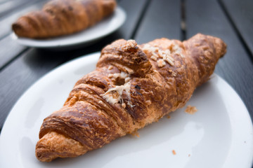 Brioches farcite su  piattini appoggiati su un tavolo di legno a doghe grigio antracite