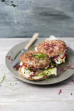 Veggie burger, wholemeal, vegan, with salad, radish, tomato, rock chives cress, yoghurt herb sauce