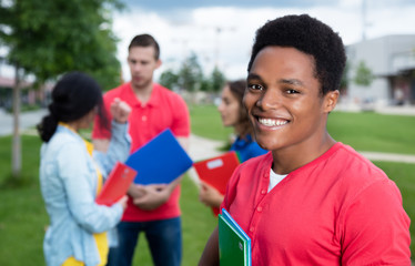 Lachender Student aus Afrika mit anderen Studenten