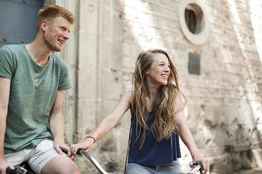 Couple with bicycles in front of an old church watching something
