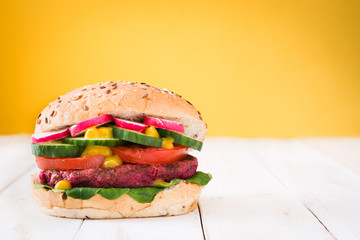 Veggie beet burger on yellow background

