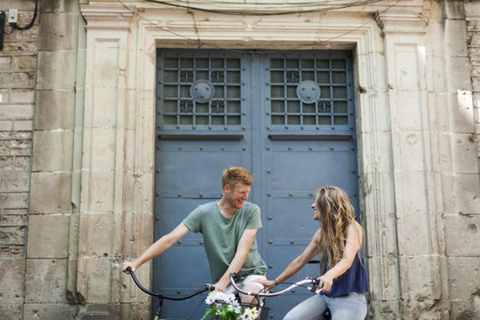 Spain, Barcelona, laughing couple with bicycles