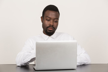 junger Geschäftsmann an Laptop / PC / Computer sitzt und zeigt verschiedene Emotionen