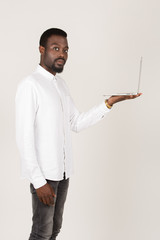 junger Geschäftsmann hält Laptop stehend Seitenansicht