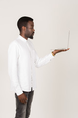 junger Geschäftsmann hält Laptop stehend Seitenansicht