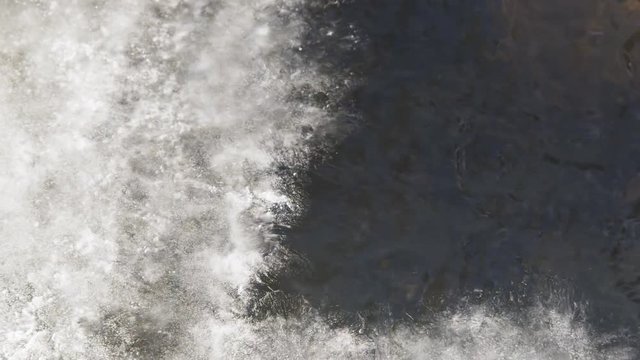 Close-up of a stream flowing under a crust of ice