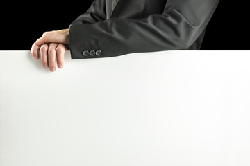 Businessman leaning on a blank white sign