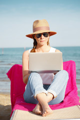 Fototapeta premium Woman working on laptop on the beach