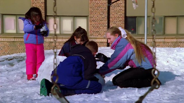 Group of children playing in the snow on a school playground