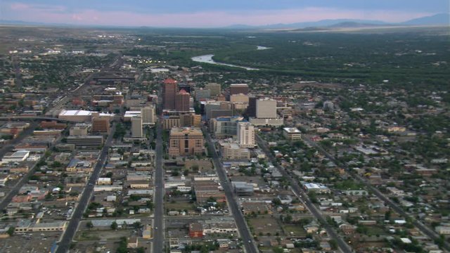 Wide flight past downtown Albuquerque with Rio Grande beyond cityscape. Shot in 2008.
