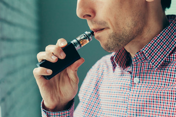 Close up on a man exhaling vapor from an electronic cigarette