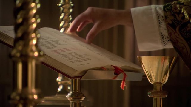 Priest's hand turning page during Eucharist