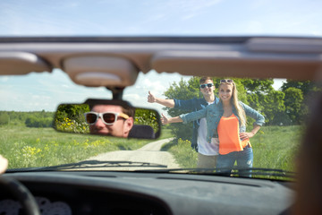 couple hitchhiking and stopping car on countryside