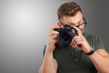 Portrait of a handsome young in glasses man with camera